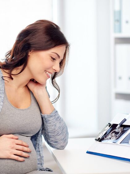 image of a pregnant woman looking over ultra sound results with a medical provider